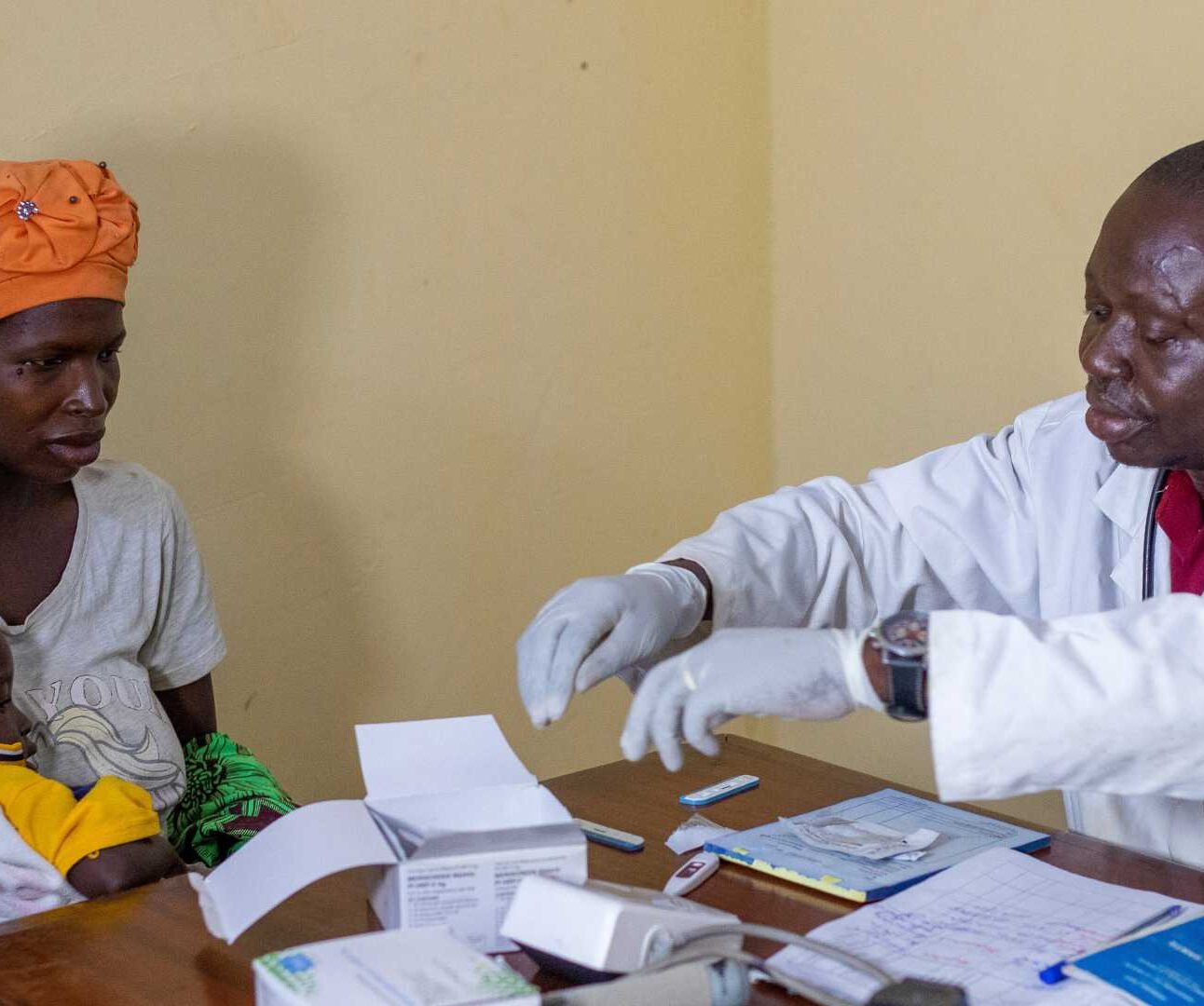 Action Against Hunger supported doctor with woman and her child.