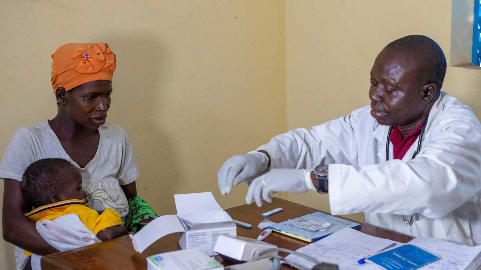 Action Against Hunger supported doctor with woman and her child.
