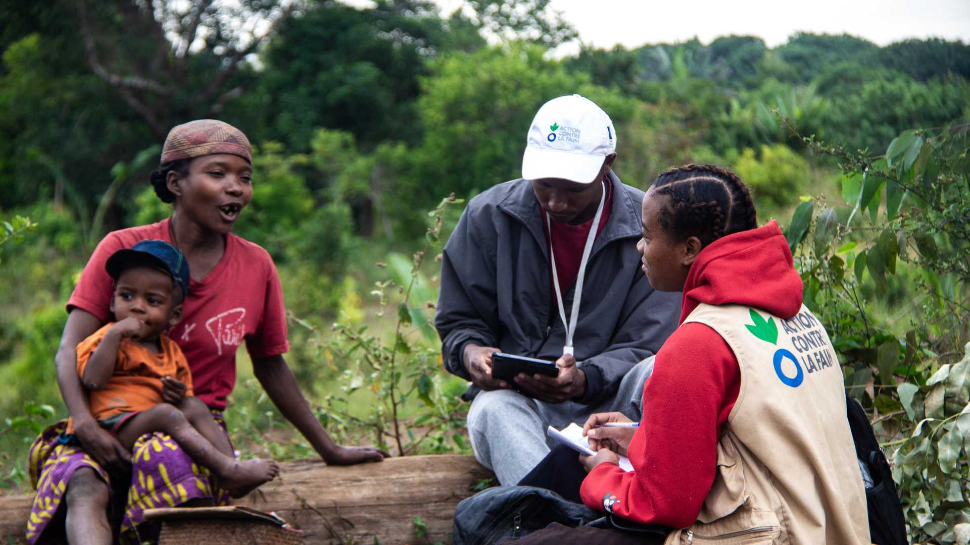 Action Against Hunger community worker in Madagascar talking to family.