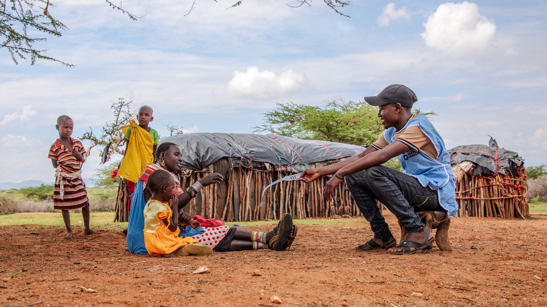 Patrick, an Action Against Hunger community health worker, assesses Rashaei for moderate acute malnutrition.