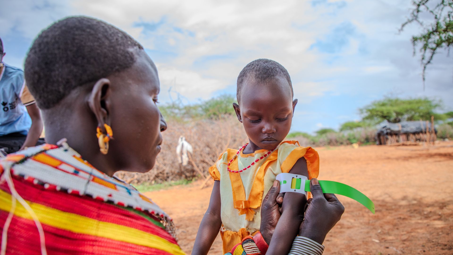 Nolntulan screens her toddler Rashaei for malnutrition.