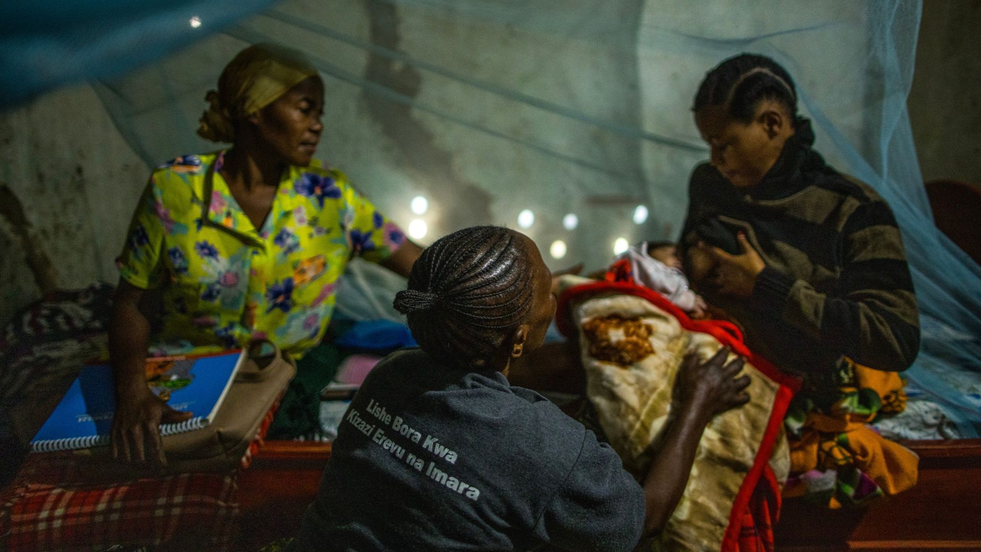 Community health worker Janeth teaches Elilumba on the best way to breastfeed.