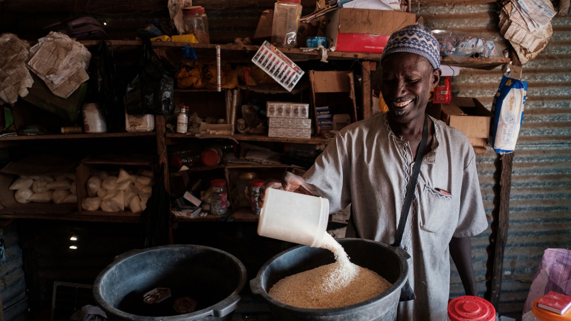 Mas measures out rice in his shop supported by Action Against Hunger in Senegal.